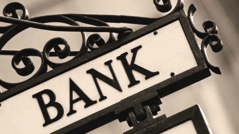 Insegna di una banca con la scritta "BANK" in primo piano, simbolo di istituto finanziario e servizi bancari.